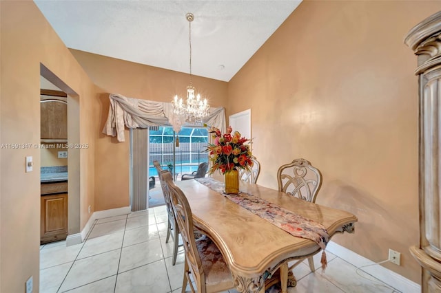 tiled dining area featuring a notable chandelier and lofted ceiling