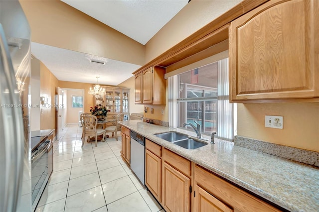 kitchen featuring appliances with stainless steel finishes, light tile patterned floors, sink, decorative light fixtures, and light stone counters