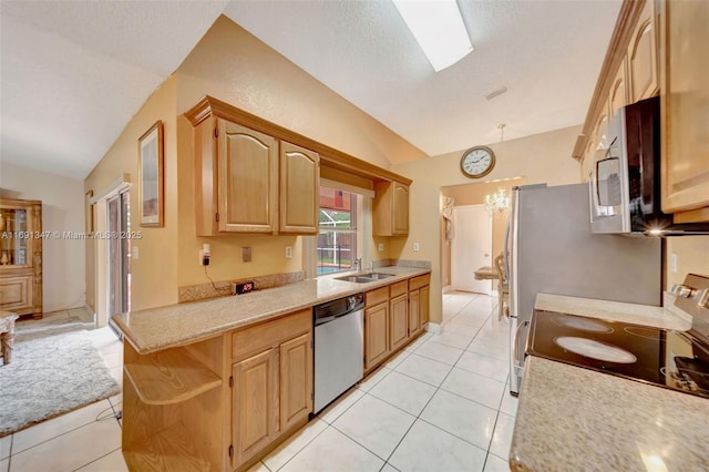 kitchen featuring light brown cabinets, lofted ceiling with skylight, sink, appliances with stainless steel finishes, and light tile patterned flooring