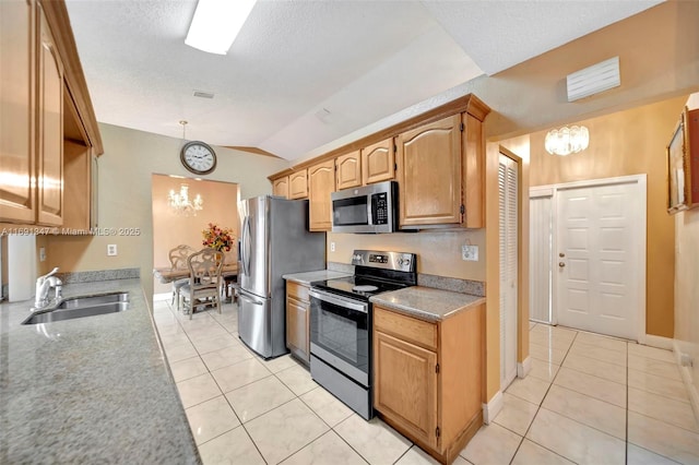 kitchen featuring appliances with stainless steel finishes, sink, light tile patterned floors, a chandelier, and lofted ceiling