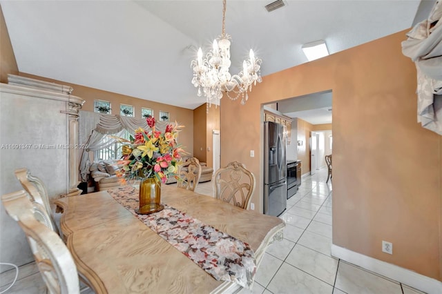 dining space with vaulted ceiling, a chandelier, and light tile patterned floors