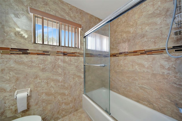 bathroom with toilet, enclosed tub / shower combo, and tile walls