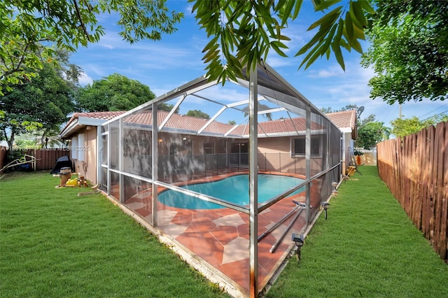 exterior space featuring glass enclosure, a fenced in pool, and a yard