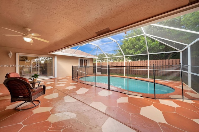 view of pool with ceiling fan, a lanai, and a patio