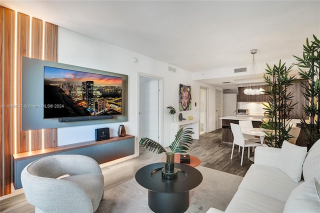 living room featuring wood-type flooring and a notable chandelier