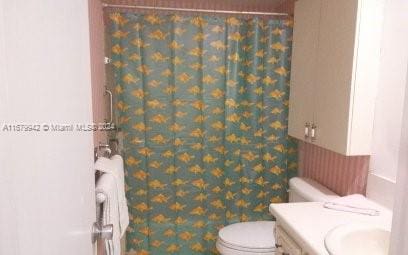 bathroom featuring vanity, radiator heating unit, and toilet