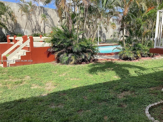 view of yard with a fenced in pool