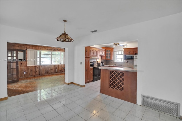 kitchen featuring plenty of natural light, black range with electric stovetop, backsplash, and sink