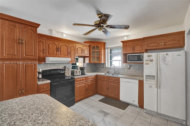 kitchen featuring backsplash, light tile patterned floors, sink, white appliances, and ceiling fan