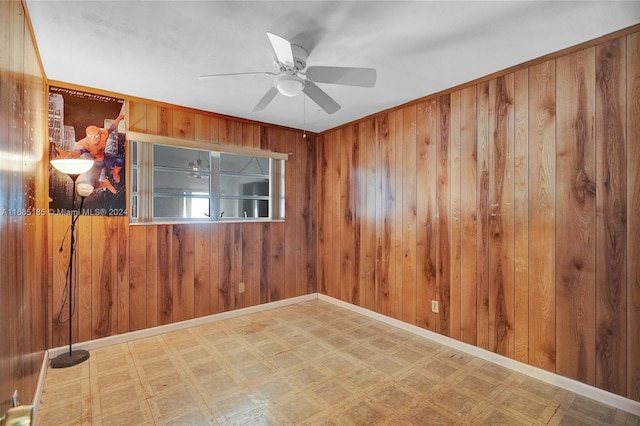 empty room with wood walls and ceiling fan