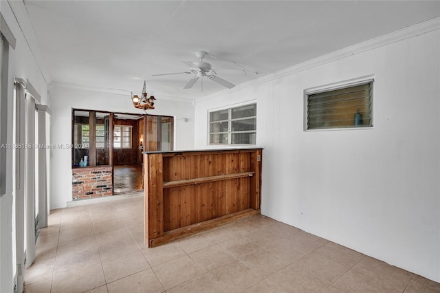 unfurnished room with light tile patterned floors, ornamental molding, and ceiling fan with notable chandelier