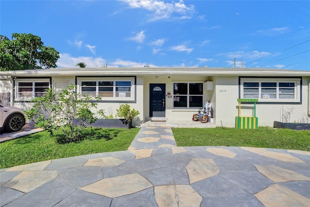 single story home featuring a front lawn