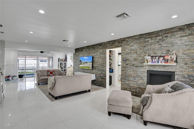 living room featuring light tile patterned flooring and a stone fireplace