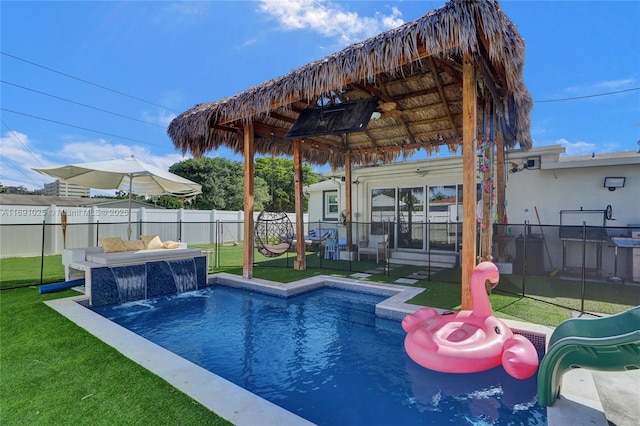 view of swimming pool featuring pool water feature, outdoor lounge area, and a lawn