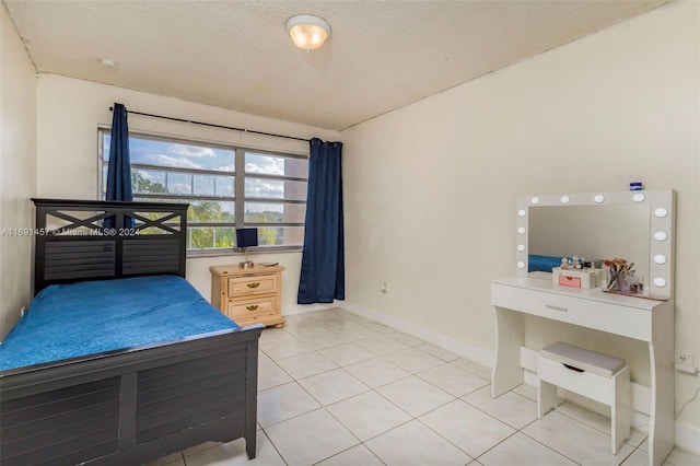 bedroom with a textured ceiling and tile patterned floors