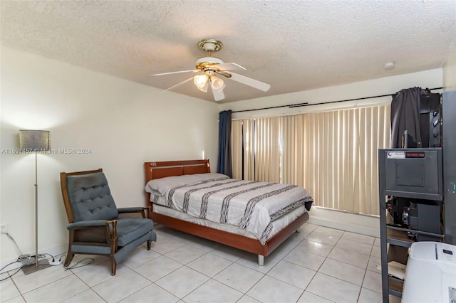 tiled bedroom with a textured ceiling and ceiling fan