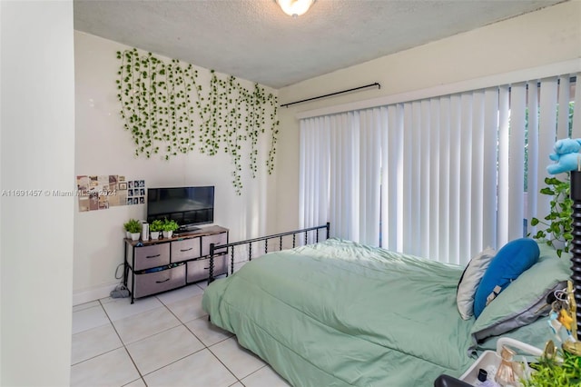 bedroom featuring tile patterned flooring and a textured ceiling