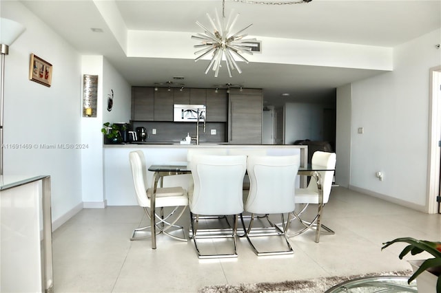 kitchen with a chandelier, a kitchen bar, tasteful backsplash, and kitchen peninsula