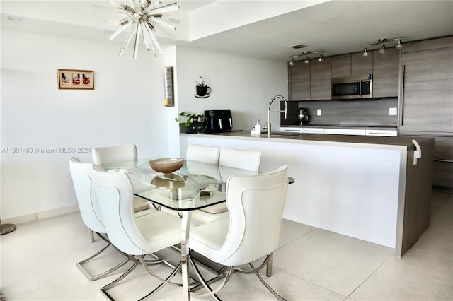 dining space featuring an inviting chandelier and sink