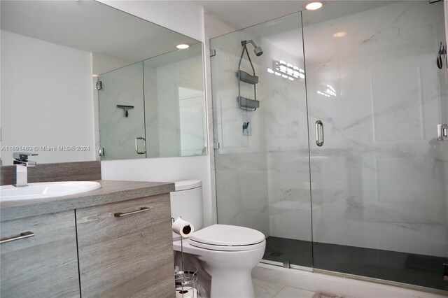 bathroom with walk in shower, vanity, and toilet