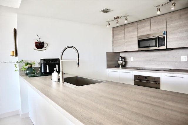 kitchen featuring appliances with stainless steel finishes, tasteful backsplash, and sink