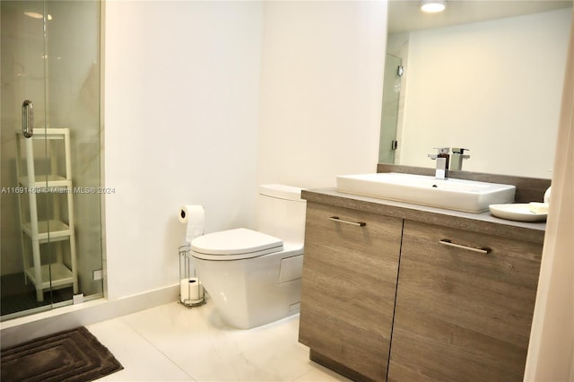 bathroom with tile patterned flooring, vanity, toilet, and a shower with shower door