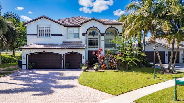 mediterranean / spanish home with a garage and a front yard