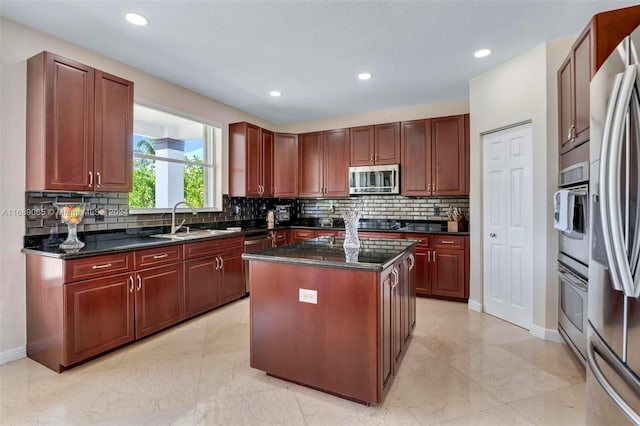 kitchen featuring decorative backsplash, a center island, sink, and appliances with stainless steel finishes