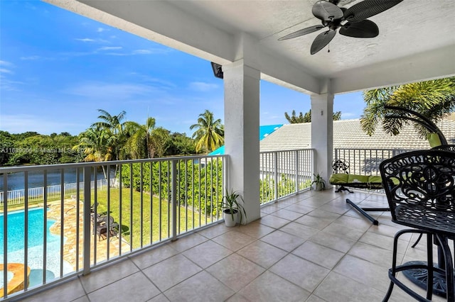 balcony featuring ceiling fan and a water view