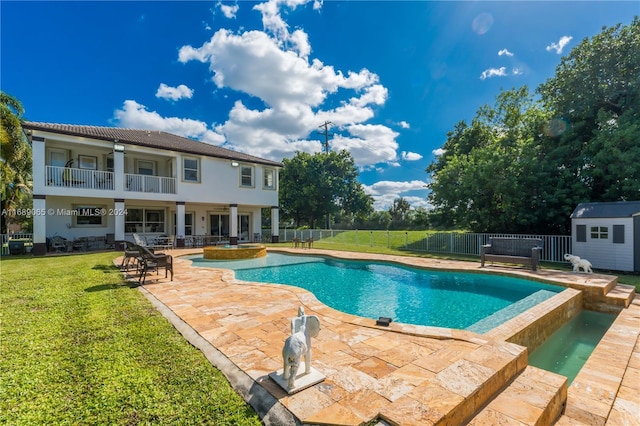 view of pool with a yard, a patio, ceiling fan, and a storage unit