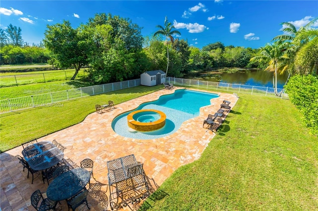 view of pool with an in ground hot tub, a water view, a storage unit, and a patio area