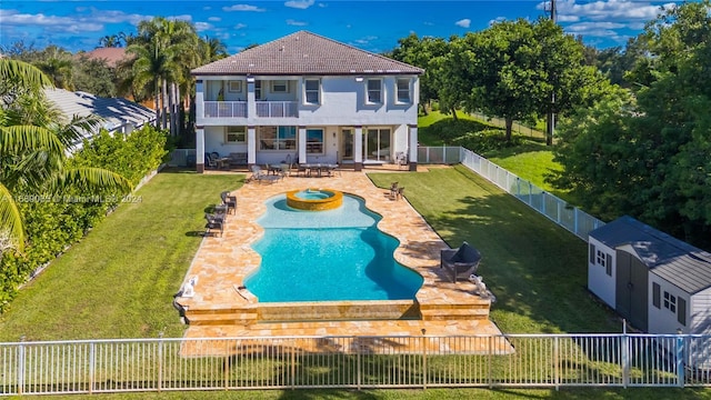 rear view of house with a balcony, a fenced in pool, a patio, and a yard