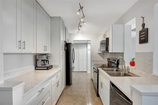 kitchen featuring stainless steel appliances, white cabinetry, sink, and light tile patterned floors