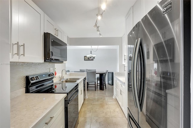 kitchen with black appliances, tasteful backsplash, white cabinetry, decorative light fixtures, and sink