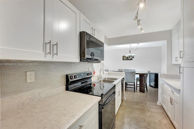 kitchen featuring black appliances, sink, light tile patterned floors, backsplash, and white cabinetry