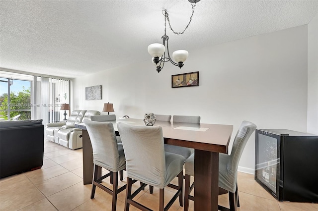 tiled dining room featuring a notable chandelier, a textured ceiling, and wine cooler