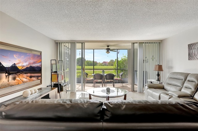 tiled living room featuring expansive windows, a textured ceiling, and ceiling fan