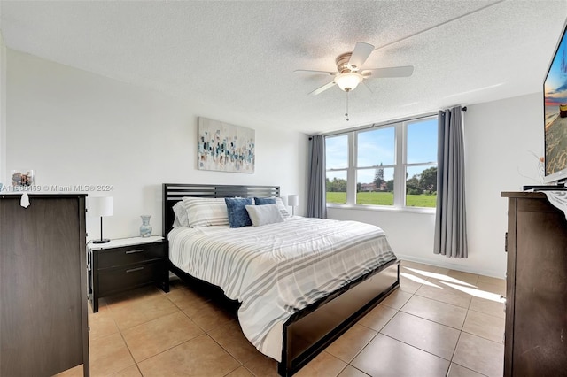 tiled bedroom with ceiling fan and a textured ceiling