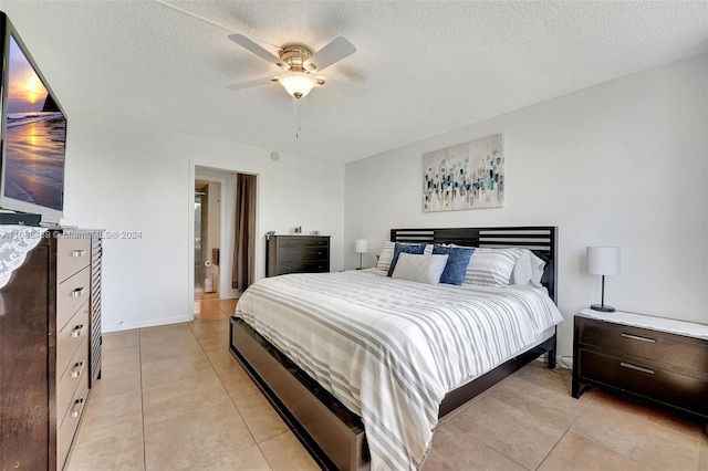 tiled bedroom with a textured ceiling and ceiling fan