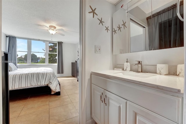 bedroom featuring a textured ceiling, sink, ceiling fan, and light tile patterned floors