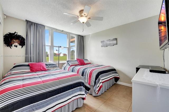 bedroom with a textured ceiling, ceiling fan, and light tile patterned floors