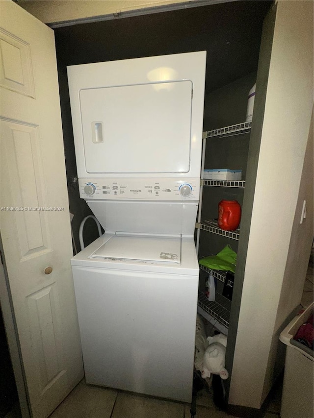 laundry area with tile patterned floors and stacked washer / drying machine