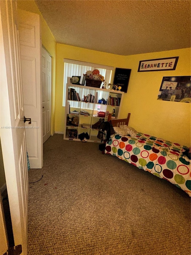 bedroom with a textured ceiling and carpet flooring