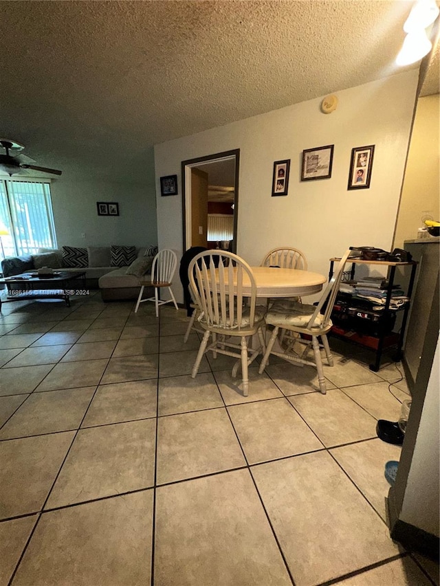 dining space featuring a textured ceiling and tile patterned floors