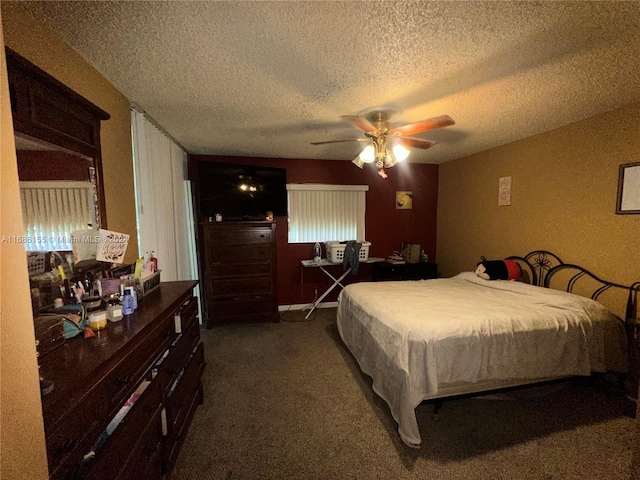 bedroom featuring a textured ceiling, dark colored carpet, and ceiling fan