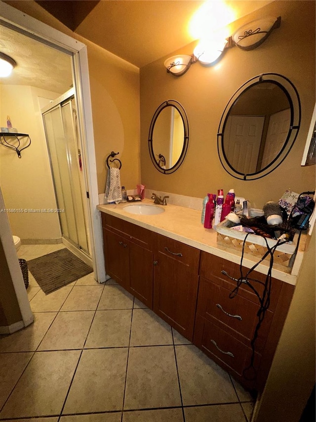 bathroom with vanity, a shower with door, and tile patterned flooring