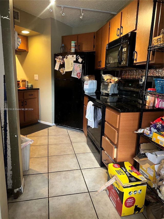 kitchen with black appliances, a textured ceiling, and light tile patterned floors