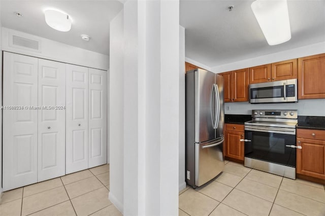 kitchen with light tile patterned flooring and appliances with stainless steel finishes