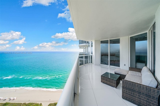 balcony with a water view and a view of the beach