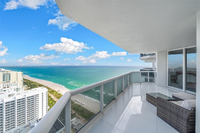 balcony featuring a view of the beach and a water view